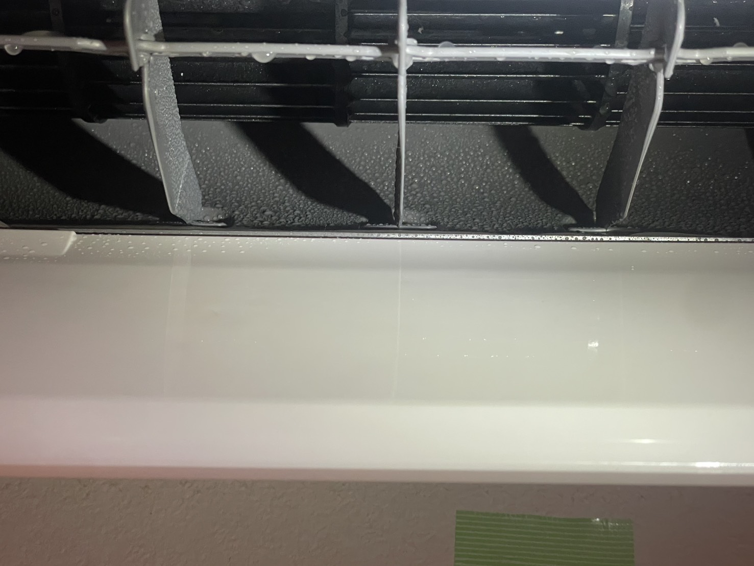 名古屋市西区桂木様邸のエアコンクリーニング。施工後：エアコン内部の熱交換器とルーバーに洗剤と水滴が付着。洗浄作業中。