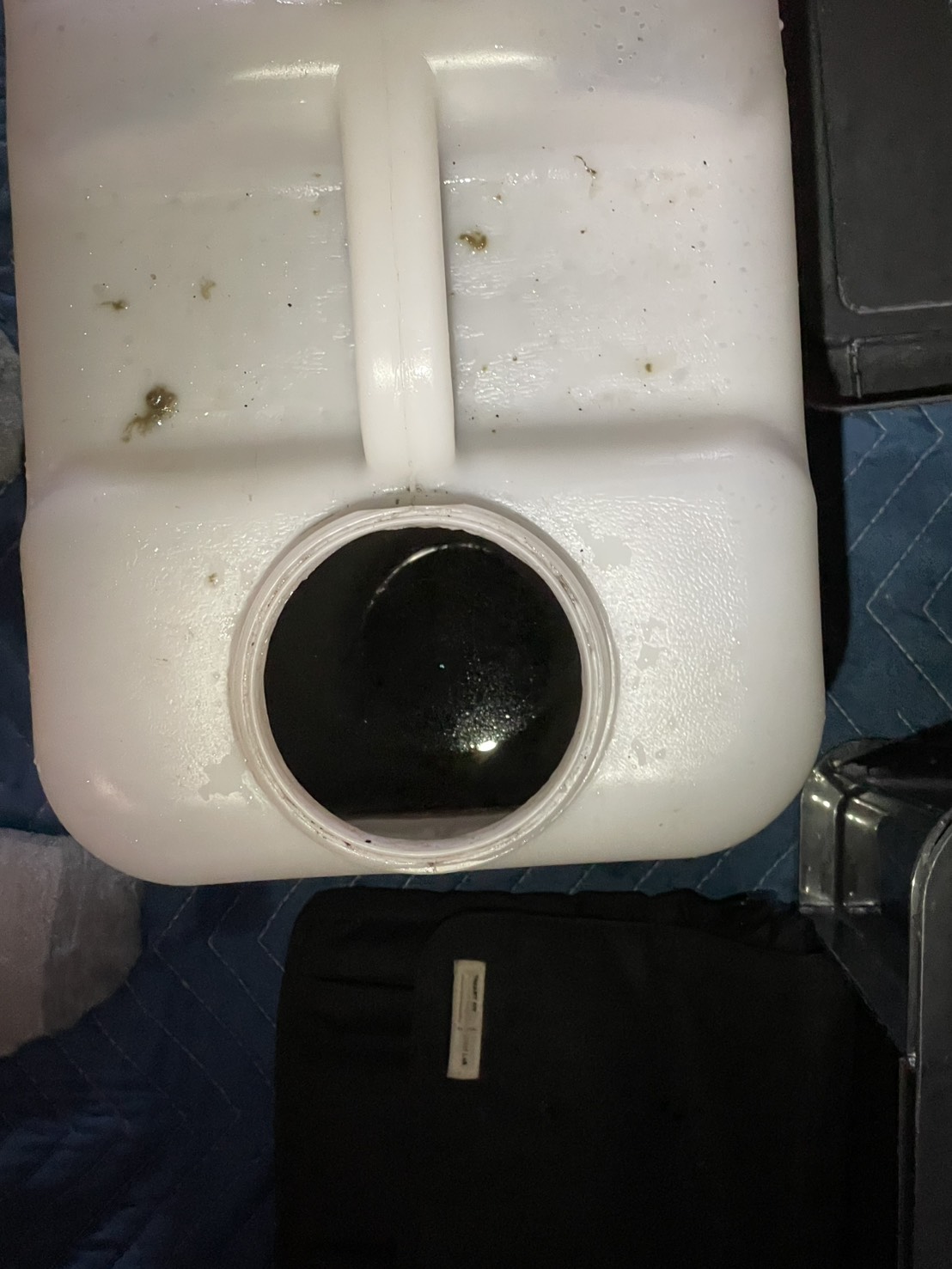 名古屋市昭和区篠塚様邸のエアコンクリーニング。洗浄で出た汚水:容器に溜まった真っ黒な汚水